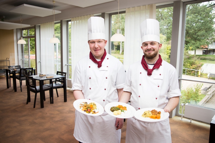 Essen auf Teller von 2 Köchen präsentiert im Speisesaal Essen auf Teller von 2 Köchen präsentiert im Speisesaal